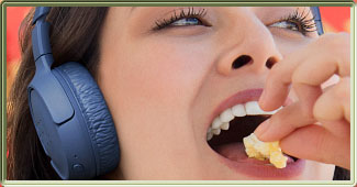 Visuel du Casque JBL Tune 570BT portée par une jeune femme mangeant du popcorn